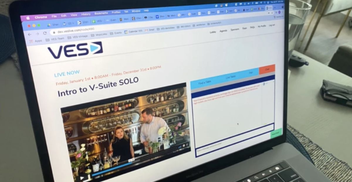 A laptop showing a live V-Suite Solo session page with video and chat